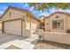 Single-story home with desert landscaping, gated front porch, and two-car garage at 7824 Homing Pigeon St, North Las Vegas, NV 89084