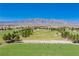 Aerial view of golf course and driving range with desert mountain backdrop at 7824 Homing Pigeon St, North Las Vegas, NV 89084