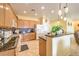 Spacious kitchen featuring granite counters, tiled flooring, light wood cabinets, and updated appliances at 7824 Homing Pigeon St, North Las Vegas, NV 89084