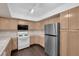 Bright kitchen featuring stainless steel refrigerator, light wood cabinets, and track lighting illuminating work areas at 7950 W Flamingo Rd # 2019, Las Vegas, NV 89147