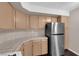 Well-lit kitchen with wooden cabinets, tile countertops, and a stainless steel refrigerator at 7950 W Flamingo Rd # 2019, Las Vegas, NV 89147