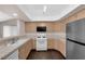 Bright eat-in kitchen features tile counters, gas range, microwave, wood cabinets, and stainless fridge at 7950 W Flamingo Rd # 2019, Las Vegas, NV 89147