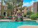 Community pool area featuring a rock waterfall, lounge seating, and tropical landscaping at 7950 W Flamingo Rd # 2019, Las Vegas, NV 89147