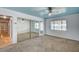 Spacious bedroom featuring carpet flooring, a ceiling fan, mirrored closet doors, and large window at 804 Cherry Dr, Henderson, NV 89002