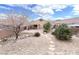 Landscaped backyard featuring desert landscaping, stone accents, and a covered patio area at 8161 Cane Creek Mill Ct, Las Vegas, NV 89131