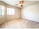 Bright bedroom featuring carpeted floors, two windows, and a ceiling fan at 8161 Cane Creek Mill Ct, Las Vegas, NV 89131