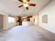 Spacious living room with neutral carpet, ceiling fan, and open floor plan to the kitchen at 8161 Cane Creek Mill Ct, Las Vegas, NV 89131