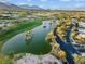 Breathtaking aerial view featuring a tranquil lake with palm-covered islands and lush landscaping near luxury homes at 82 Glade Hollow Dr, Las Vegas, NV 89135