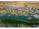Expansive aerial shot showcasing a serene lake, verdant landscaping, and luxury homes in a Primary-planned community at 82 Glade Hollow Dr, Las Vegas, NV 89135