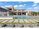 Stunning exterior view of a modern home featuring a large pool, landscaped yard, and luxurious outdoor living spaces at 82 Glade Hollow Dr, Las Vegas, NV 89135