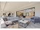 Spacious indoor/outdoor living area featuring a large gray sofa, modern furnishings, and seamless access to the patio at 82 Glade Hollow Dr, Las Vegas, NV 89135