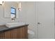 Modern powder room featuring a vessel sink, stylish faucet, wood vanity, and contemporary lighting at 82 Glade Hollow Dr, Las Vegas, NV 89135