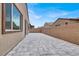 Spacious backyard featuring a modern gray paver patio, stucco fence, and house access at 851 Klamath Springs St, Henderson, NV 89011