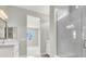 Bathroom with white vanities, framed mirrors, and glass enclosed shower at 851 Klamath Springs St, Henderson, NV 89011
