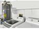 Convenient laundry room featuring a washing machine, a dryer, and a water heater at 8524 Little Fox St, Las Vegas, NV 89123