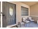 Welcoming front door with decorative glass, cozy seating, and desert landscaping at 8524 Little Fox St, Las Vegas, NV 89123
