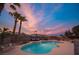 Stunning backyard pool area at twilight, featuring palm trees, an outdoor sofa, and ambient lighting at 8610 Mohawk St, Las Vegas, NV 89139