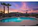 A beautifully designed backyard pool with a seating area under a trellis and landscape lighting at 8610 Mohawk St, Las Vegas, NV 89139