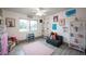 Cheerful bedroom featuring large window, playful decor, and gray wood-look floors at 8610 Mohawk St, Las Vegas, NV 89139
