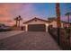Charming home featuring a two-car garage, desert landscaping, and a brick driveway under a beautiful twilight sky at 8610 Mohawk St, Las Vegas, NV 89139