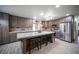Modern kitchen with stainless steel appliances, island with seating, and ample cabinet space at 8610 Mohawk St, Las Vegas, NV 89139