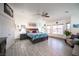 Spacious main bedroom with gray wood-look tile, ceiling fan, and large windows at 8610 Mohawk St, Las Vegas, NV 89139