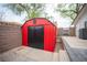 Exterior view of a red storage shed in a well-kept backyard, adding functional space at 8610 Mohawk St, Las Vegas, NV 89139