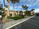 Community clubhouse with palm trees, grass, and paved parking at 8985 S Durango Dr # 1034, Las Vegas, NV 89113