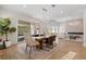 Open-concept living space showcases a dining area with a wooden table, modern chandelier, and access to the patio at 921 Granger Farm Way, Las Vegas, NV 89145