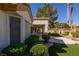 View of the backyard, featuring a covered patio and lush landscaping with mature trees and manicured bushes at 9524 Quail Ridge Dr, Las Vegas, NV 89134