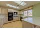 Eat-in kitchen featuring wood floors, double oven, garden window and light wood cabinets and floral wallpaper at 9524 Quail Ridge Dr, Las Vegas, NV 89134