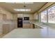 Eat-in kitchen featuring light wood cabinets, double oven, garden window and floral wallpaper at 9524 Quail Ridge Dr, Las Vegas, NV 89134