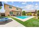 Expansive backyard with a refreshing pool, sun loungers, and lush green lawn perfect for relaxation at 9588 Vital Crest St, Las Vegas, NV 89123