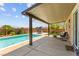 Inviting backyard oasis with a sparkling pool, covered patio, and comfortable seating area at 9588 Vital Crest St, Las Vegas, NV 89123