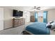 Inviting bedroom features a blue bedspread, matching dresser, and views from the bright windows at 9588 Vital Crest St, Las Vegas, NV 89123