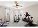 Bright exercise room features windows with curtains, a ceiling fan, treadmill, and exercise bike at 9588 Vital Crest St, Las Vegas, NV 89123