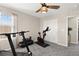 Bright workout room with ceiling fan, treadmill, stationary bike, weights and a large window at 9588 Vital Crest St, Las Vegas, NV 89123