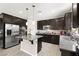 Well-equipped kitchen with stainless appliances, island and dark wood cabinetry at 9588 Vital Crest St, Las Vegas, NV 89123
