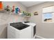 Well-lit laundry room featuring modern appliances, shelves and a window at 9588 Vital Crest St, Las Vegas, NV 89123