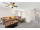 Spacious living room with plush gray carpet, ceiling fan, and comfy brown sectional sofa at 9588 Vital Crest St, Las Vegas, NV 89123