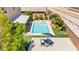 Backyard pool area features a spa, ample seating, modern patio covering, and lush landscaping at 9588 Vital Crest St, Las Vegas, NV 89123