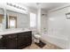 Bright bathroom featuring a dark vanity, tub with shower, and window with blinds at 9636 Salford Isle St, Las Vegas, NV 89123