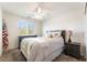 Stylish bedroom featuring a ceiling fan, natural light, and a bed with decorative pillows at 9636 Salford Isle St, Las Vegas, NV 89123