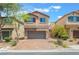 Two-story home featuring a two-car garage and desert landscaping at 9636 Salford Isle St, Las Vegas, NV 89123