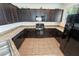 Spacious kitchen features modern appliances, dark wood cabinets and granite countertops at 9636 Salford Isle St, Las Vegas, NV 89123