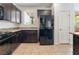 Modern kitchen features dark cabinetry, stainless appliances and granite countertops at 9636 Salford Isle St, Las Vegas, NV 89123