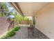 Inviting covered patio with brick pavers, small table and chairs, and vibrant greenery at 9636 Salford Isle St, Las Vegas, NV 89123