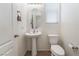 Charming powder room features a pedestal sink, mirror and neutral color palette at 9636 Salford Isle St, Las Vegas, NV 89123