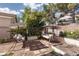 Charming backyard featuring comfortable porch swings, mature trees, and a decorative iron fence at 1709 Pacific Panorama Pl, Las Vegas, NV 89144