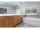 Bathroom with a bathtub, vanity with double sinks and tiled floors at 1709 Pacific Panorama Pl, Las Vegas, NV 89144
